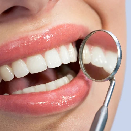 Close-up of a person's mouth with a dental mirror reflecting teeth.
