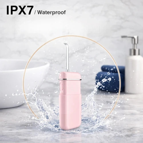 Pink waterproof device with water splashes on a bathroom background